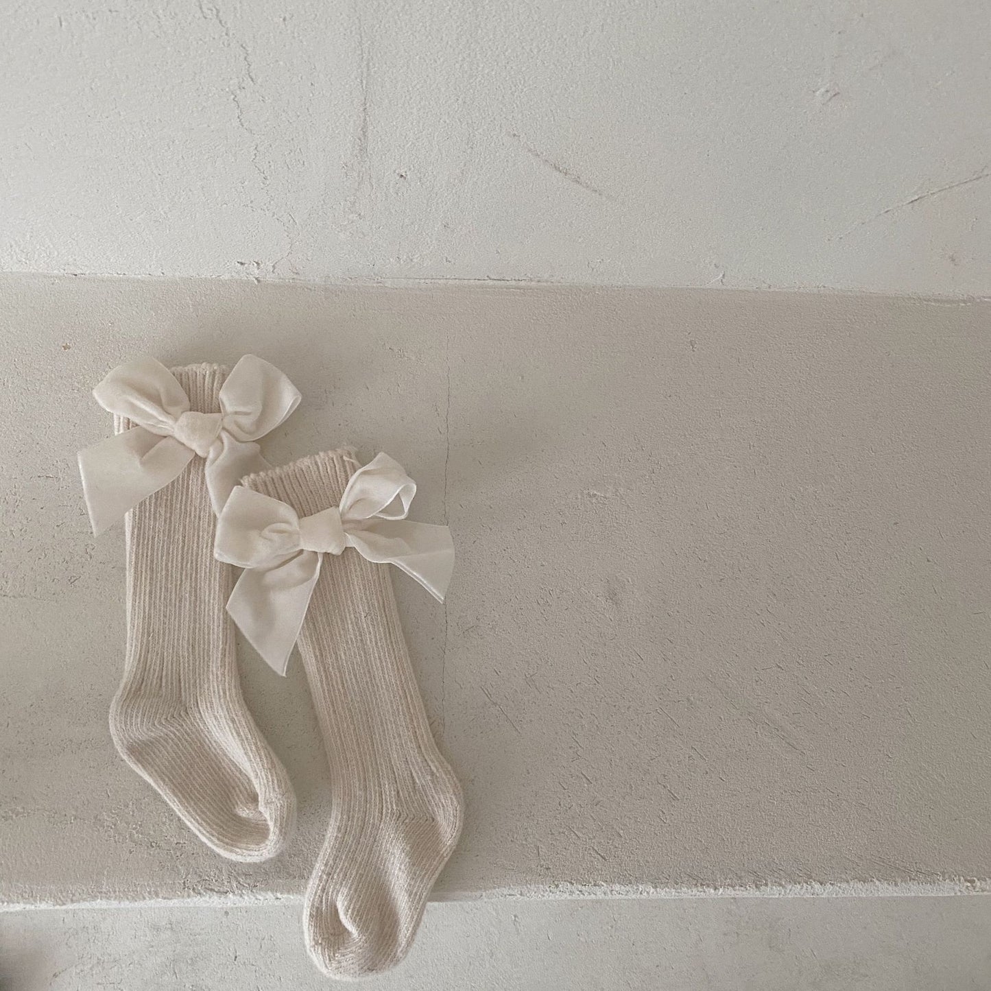 Oluuu. Baby Wollsocken mit Schleifen-Design